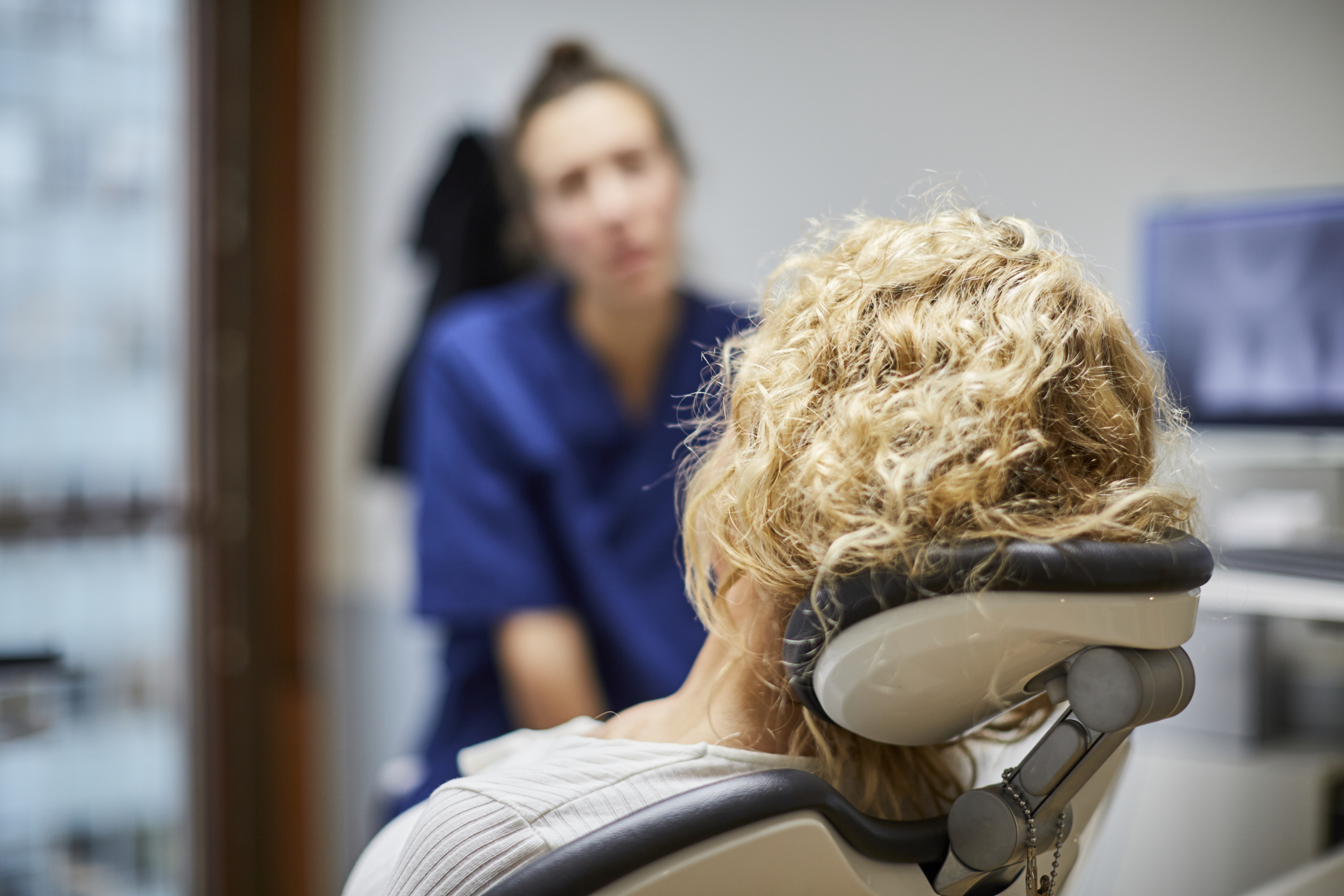 Tandläkare talar med patient om tandreglering.